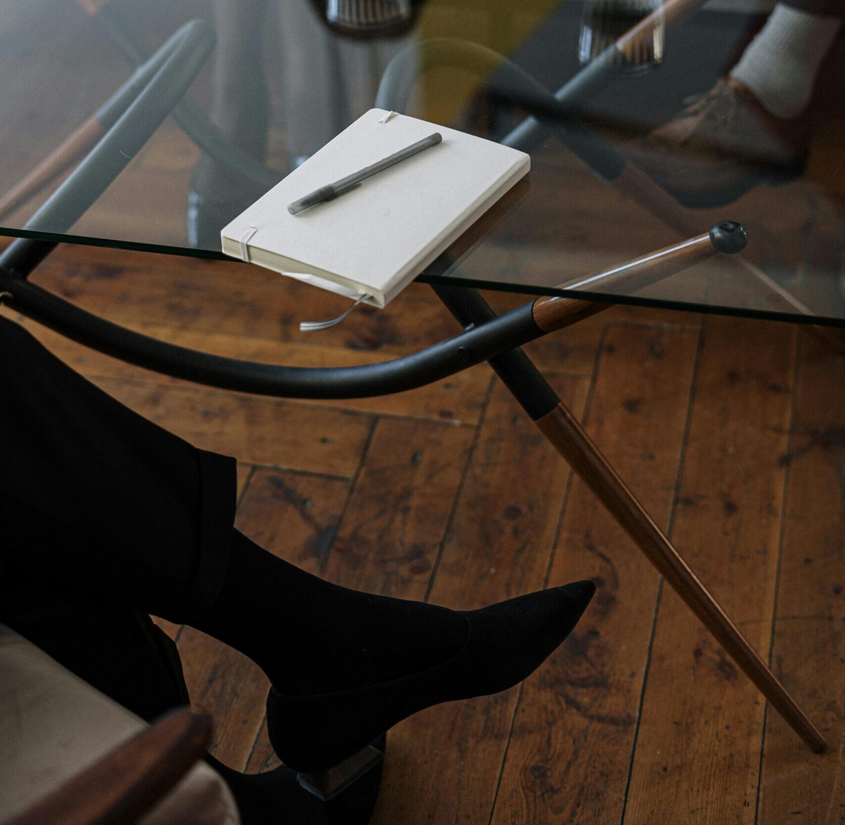 Close-up of a counseling session with two glasses of water and a notepad on a glass table.